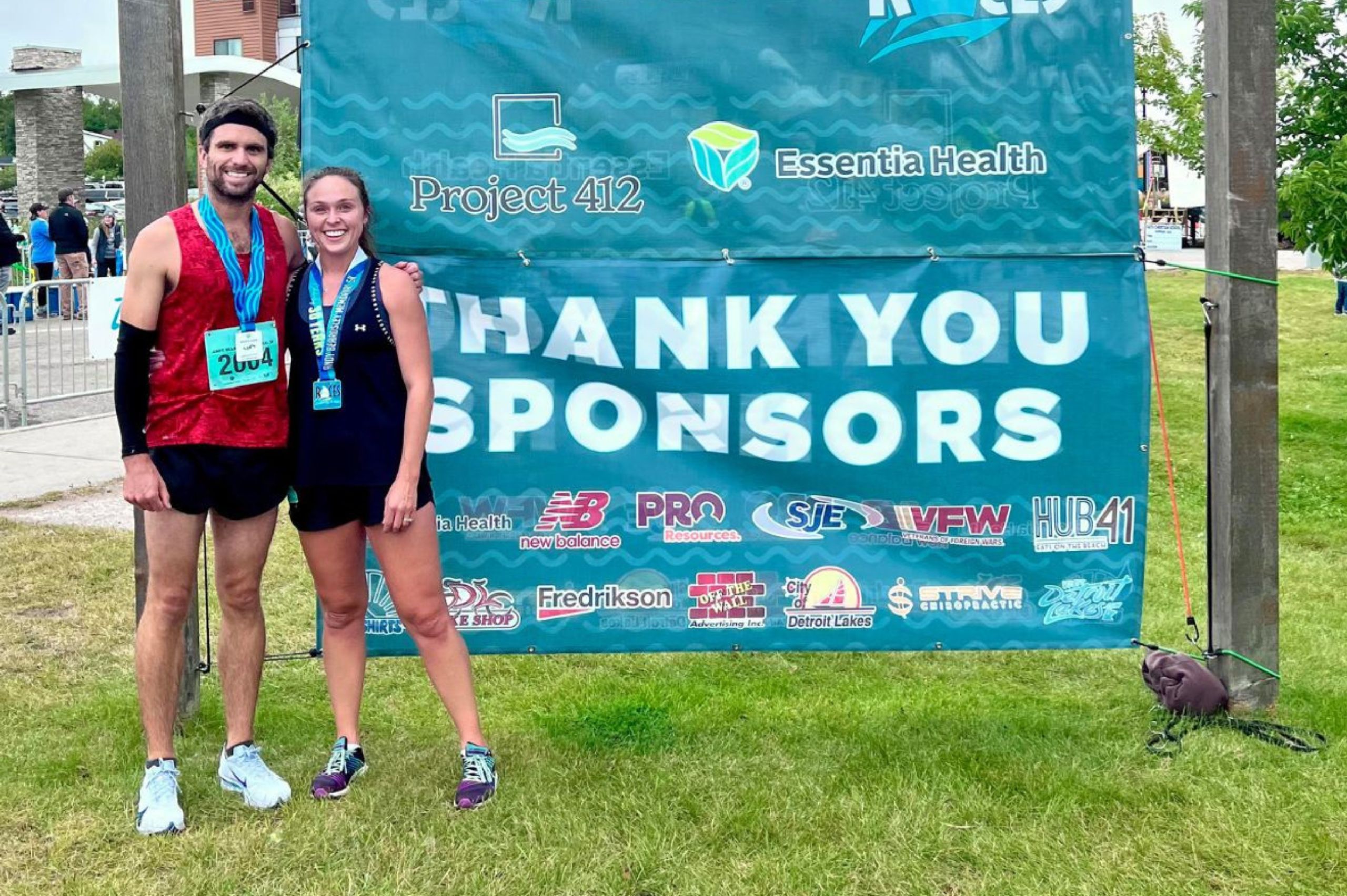 a smiling male and female standing in front of the "Thank you Sponsors" sign