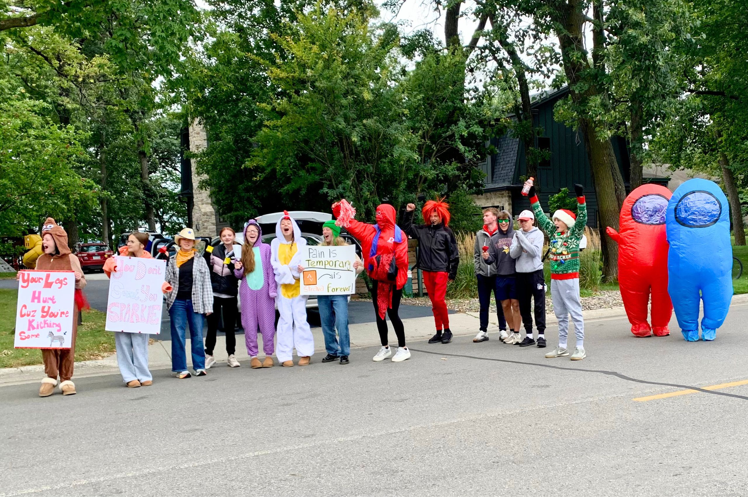 a cheer group with signs on the side of the street