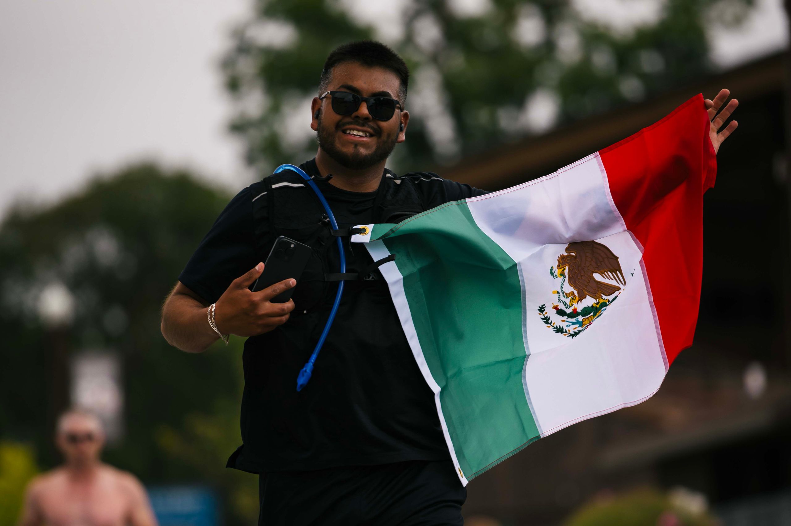 A happy man holding a Mexican flag