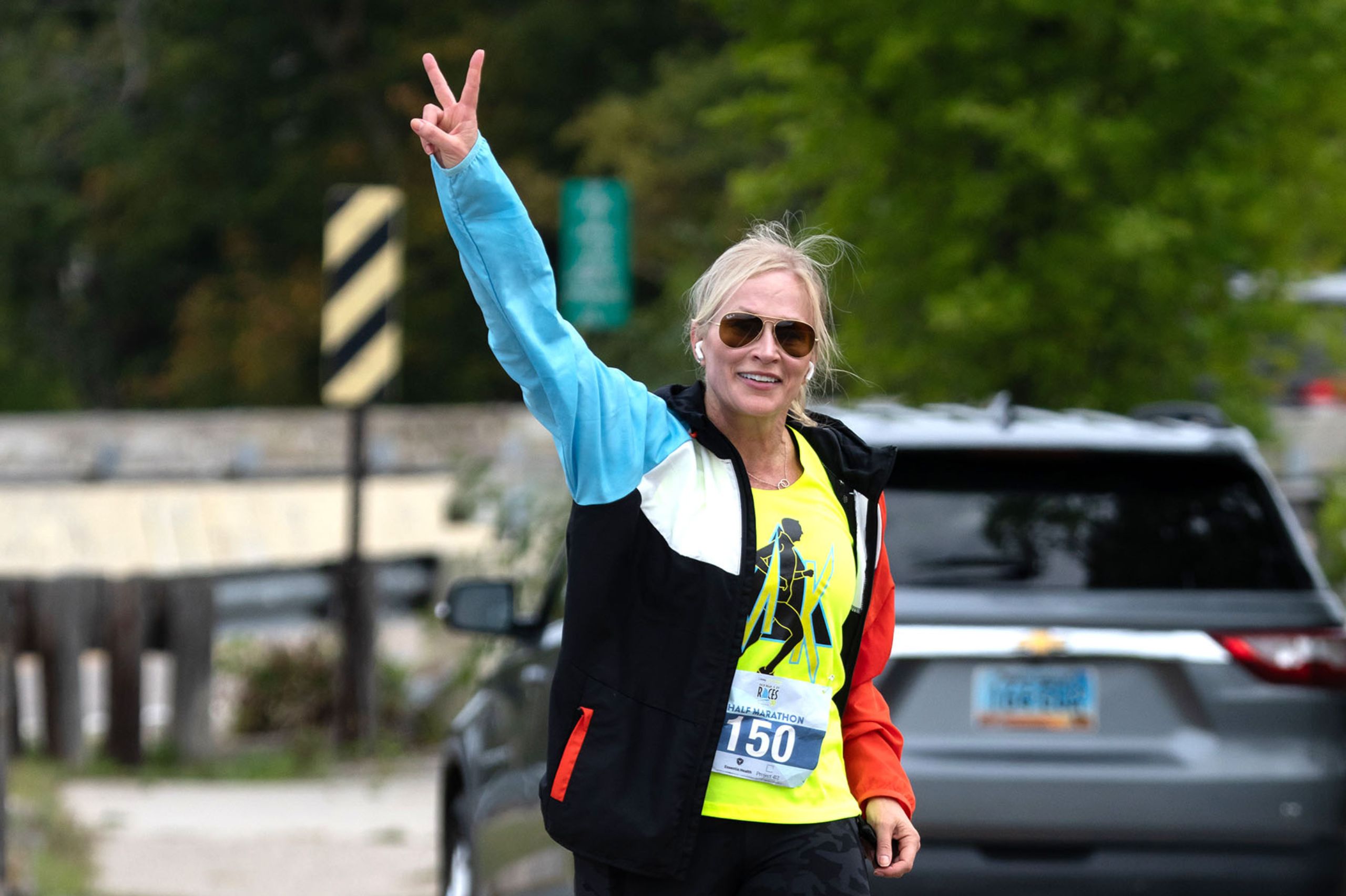 a happy beautiful woman with arm extended and peace sign